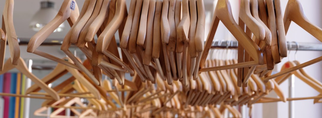 Wooden hangers on a rack at a clothing store